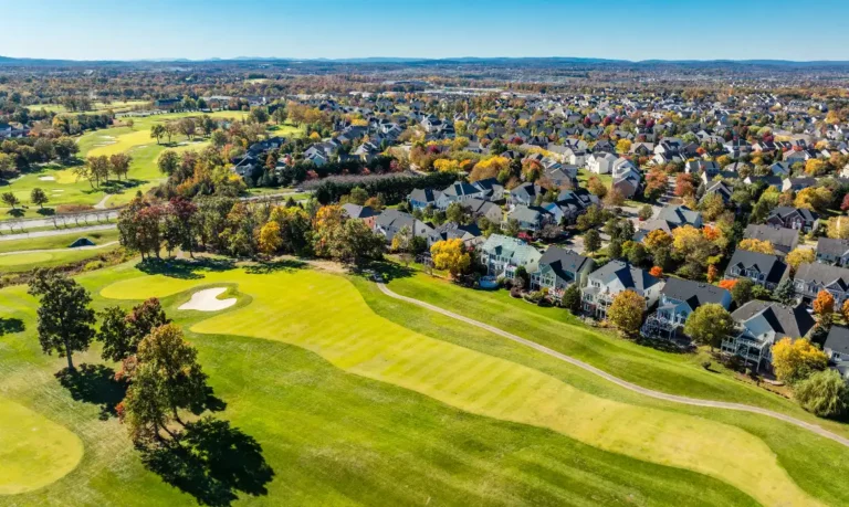 An aerial view of luxury homes situated along the golf course in Lansdowne on the Potomac, a prestigious neighborhood in Loudoun County. These high-end properties, sold by top listing agent Jean Garrell, offer scenic views and access to exclusive amenities, making them highly desirable in the local real estate market.