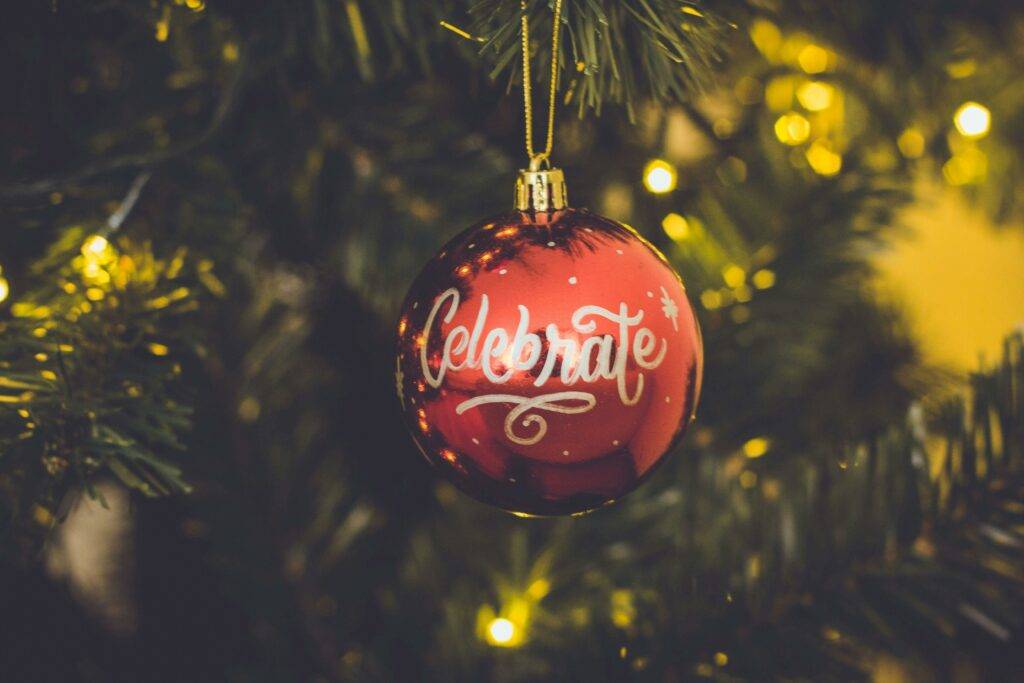 Red ornament on a tree, with “Celebrate” written on it, symbolizing the 2024 Holiday season in Loudoun County and our event and local gift guide