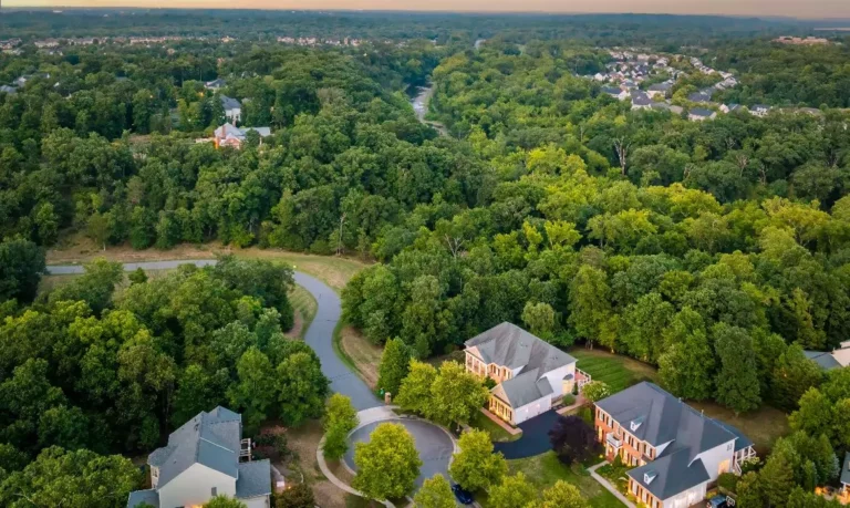 Aerial drone view of a Leesburg luxury home on a cul-de-sac surrounded by trees, sold by top Realtors the Garrell Group. The image highlights the serene setting and premium real estate in Loudoun County.