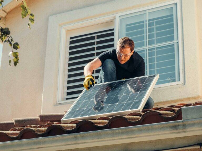 Man installs solar panels to the roof of his real estate listing in Loudoun County as recommended for sustainability and energy efficient homes in Leesburg and Ashburn